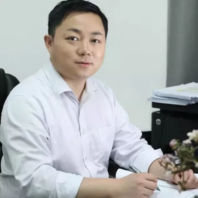 Xuhai Tang seated at his desk